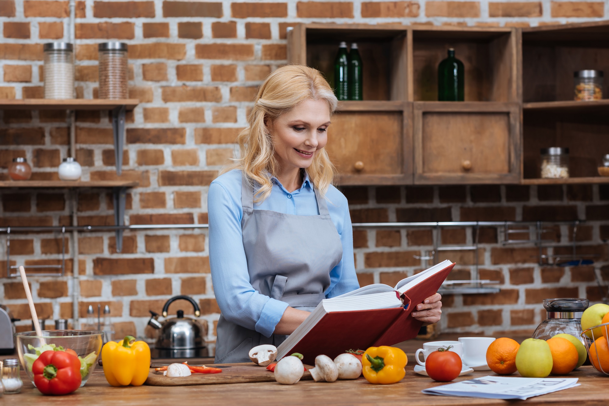 woman reading recipe book in kitchen