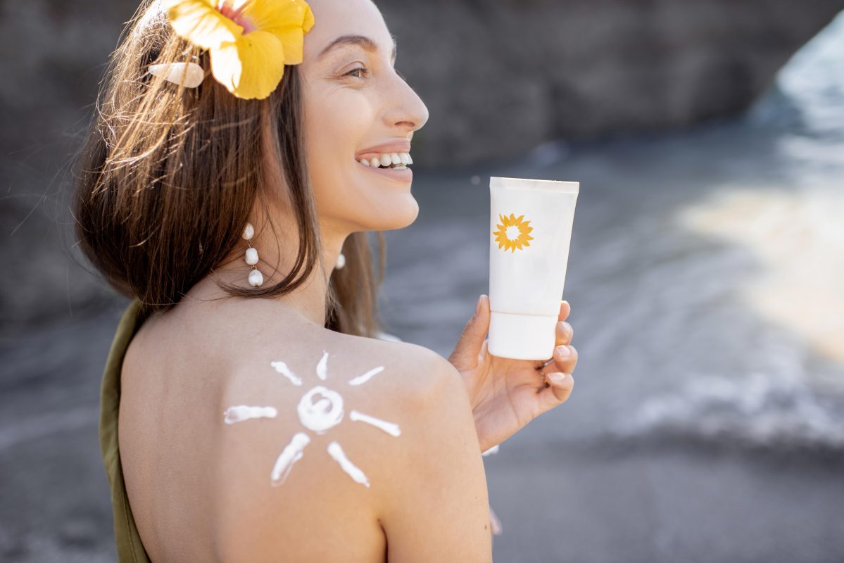 a girl holding photostable sunscreen under the sun